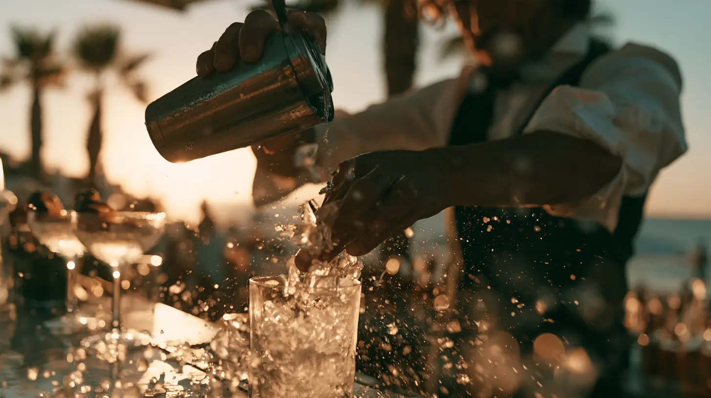 Bartender a agitar um cocktail com gelo num beach club do Algarve ao pôr do sol